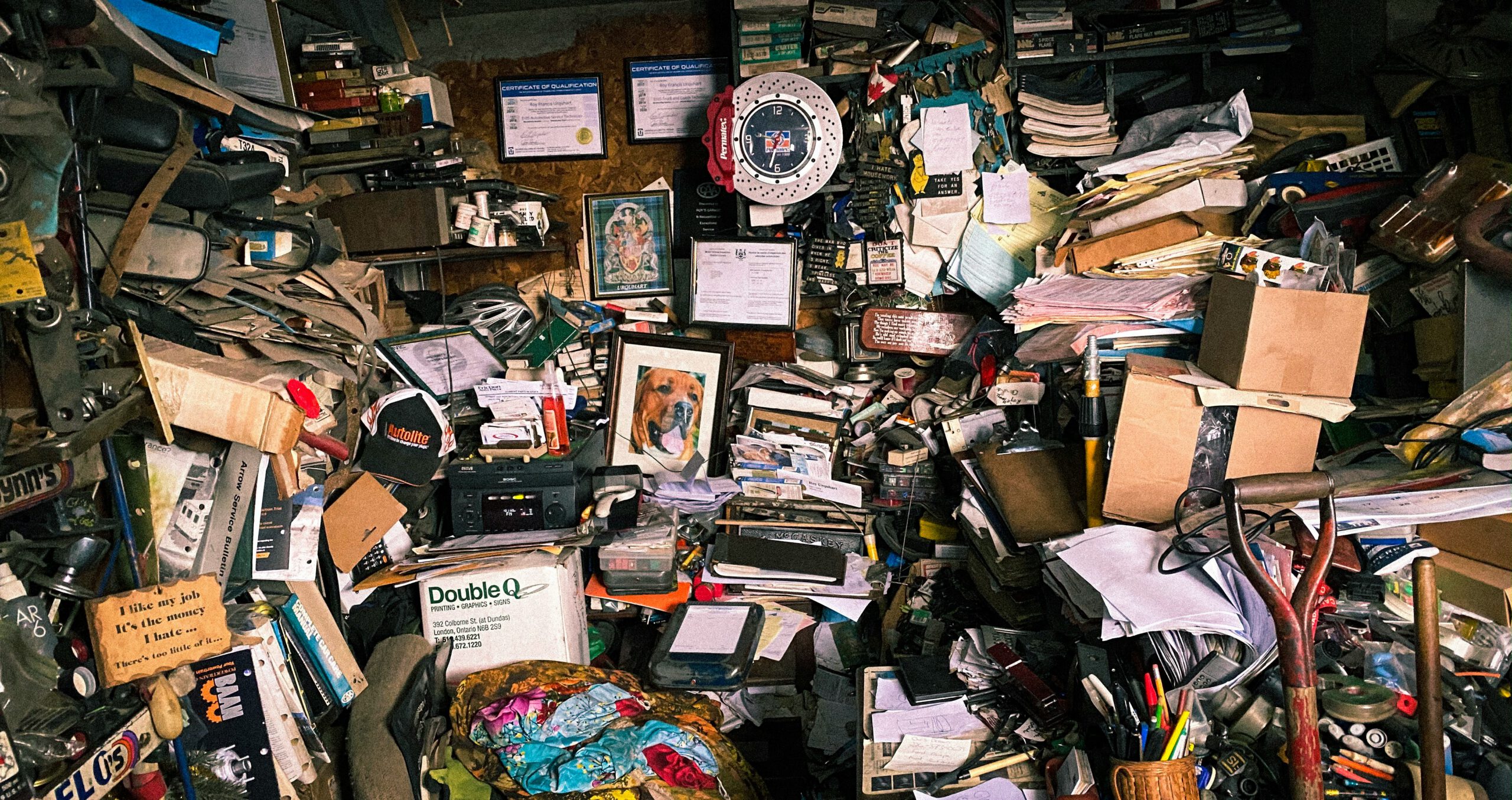 photo of an insane amount of clutter filling up a garage or a room, you can't tell because it's floor to ceiling with detritus, papers, photos, and just stuff.