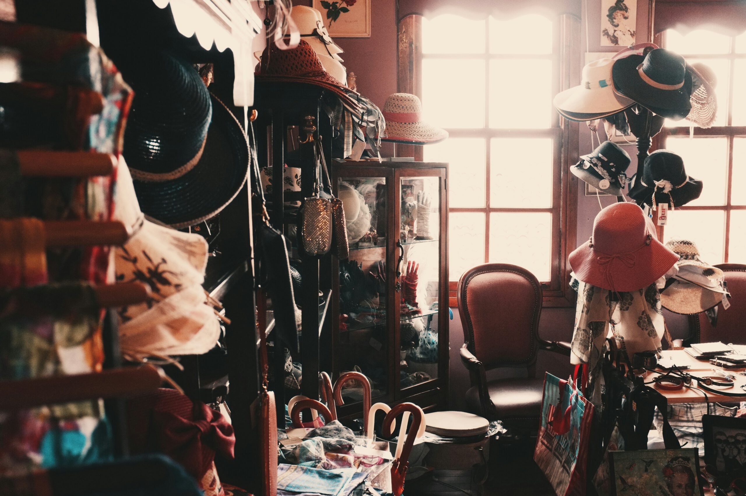 a room filled with womens' hats and umbrellas